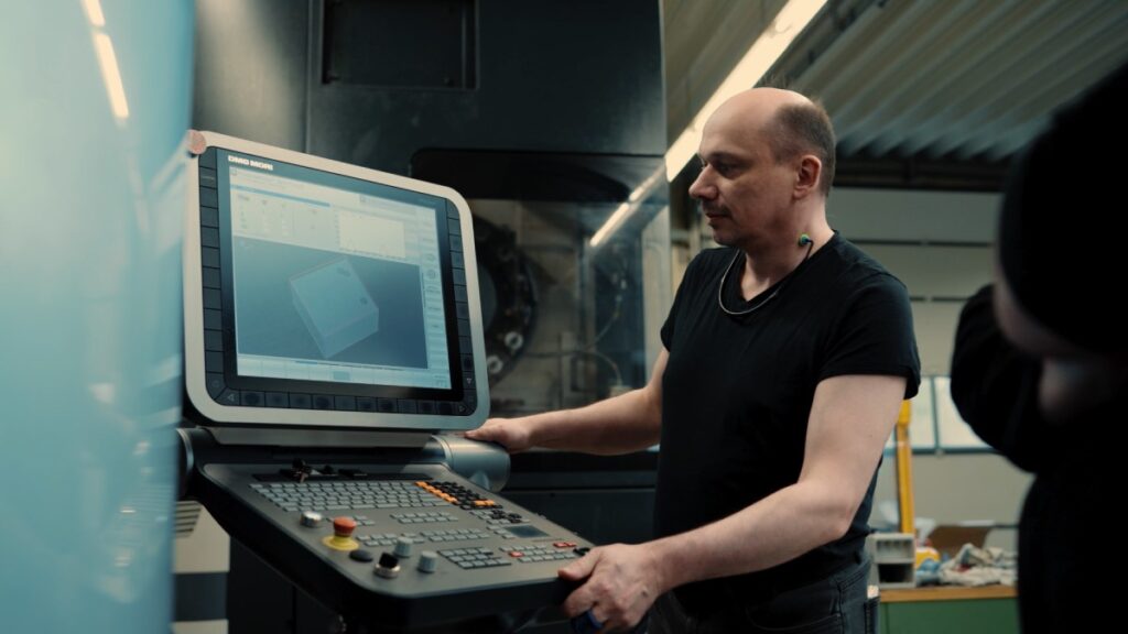 Maschinenbediener prüft Bauteil-Visualisierung am Bildschirm der CNC-Fräsmaschine