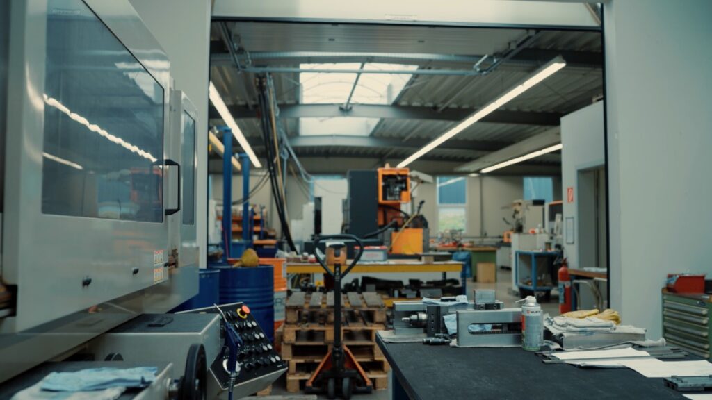 Weitwinkelansicht einer hellen Werkstatt mit CNC-Maschinen und Werkbänken
